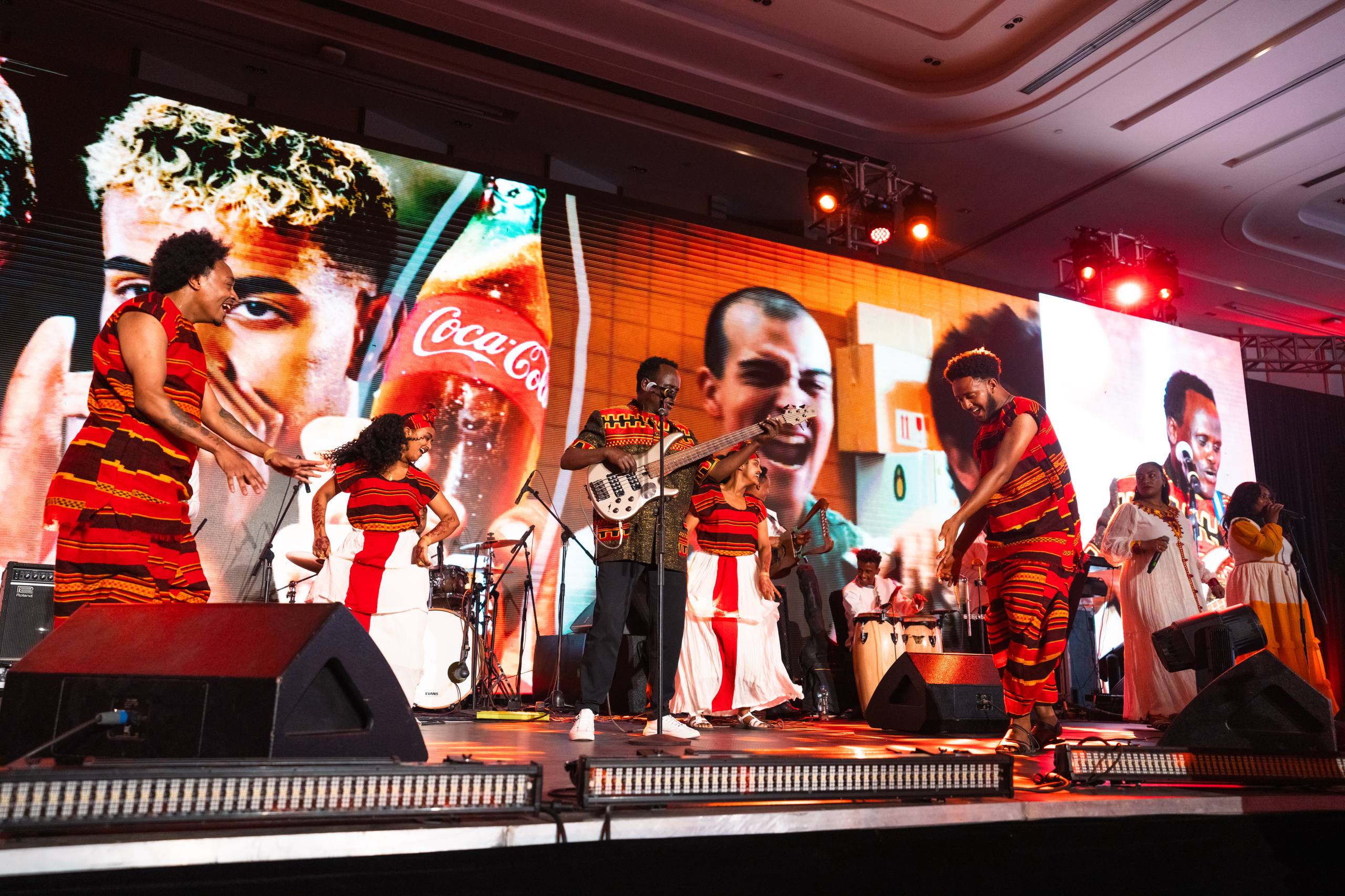 Crowded Coca-Cola World Cup finals watch party at night with a giant screen and stadium lights